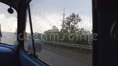 在雨天行驶时，通过旧复古车的侧窗观看。 雨点落在玻璃上
